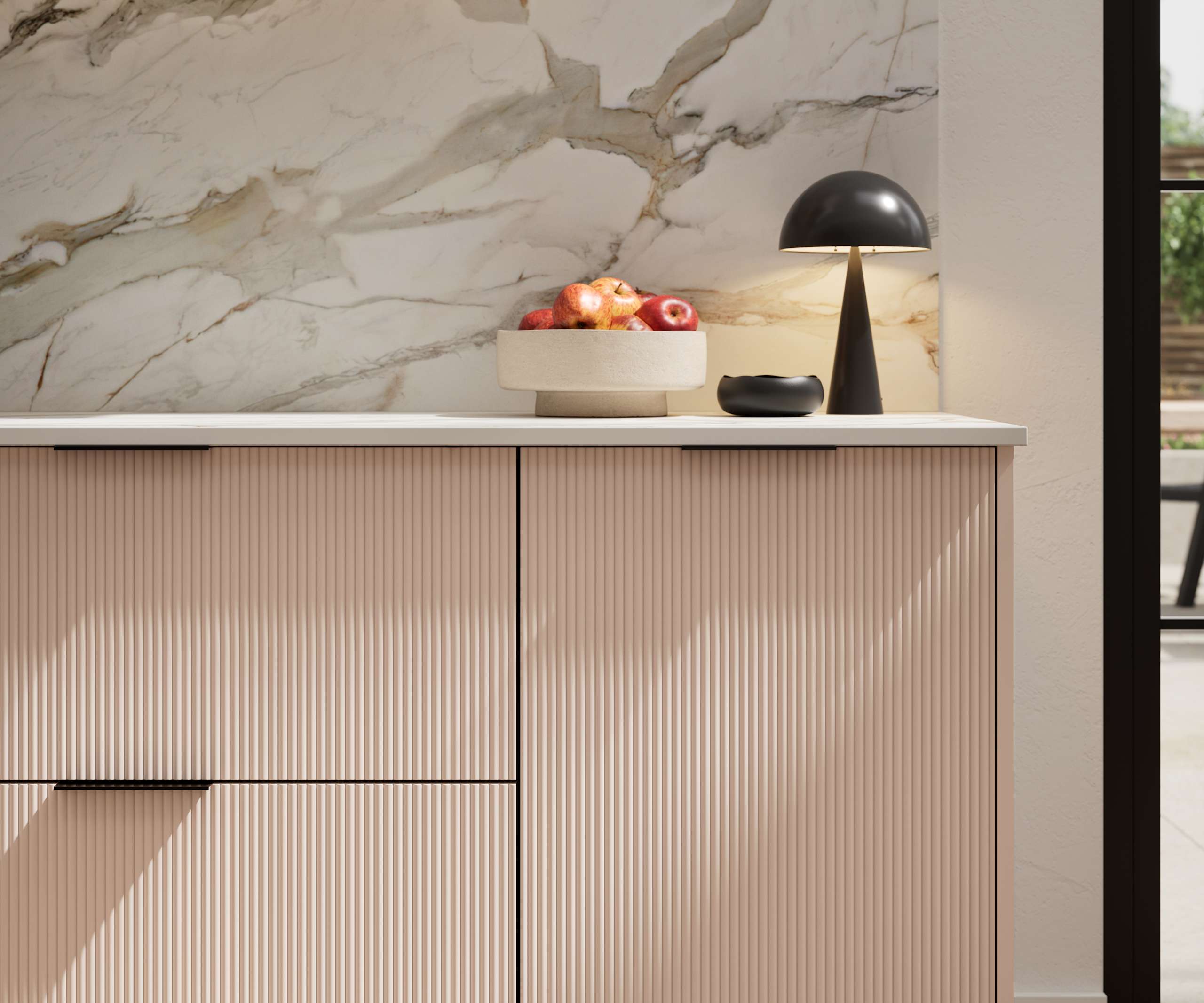 Fluted front kitchen Reed from Magnet in light neutral pink shade Chalk Blush, with a marbled splashback and black handles, herringbone wood flooring.