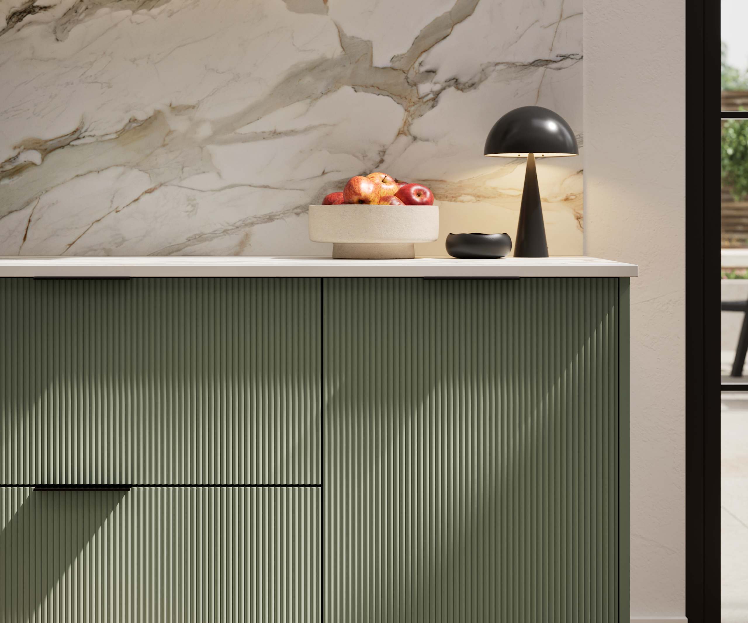 Fluted front kitchen Reed from Magnet in rich dark green shade Thyme, with a marbled splashback and black handles, herringbone wood flooring.