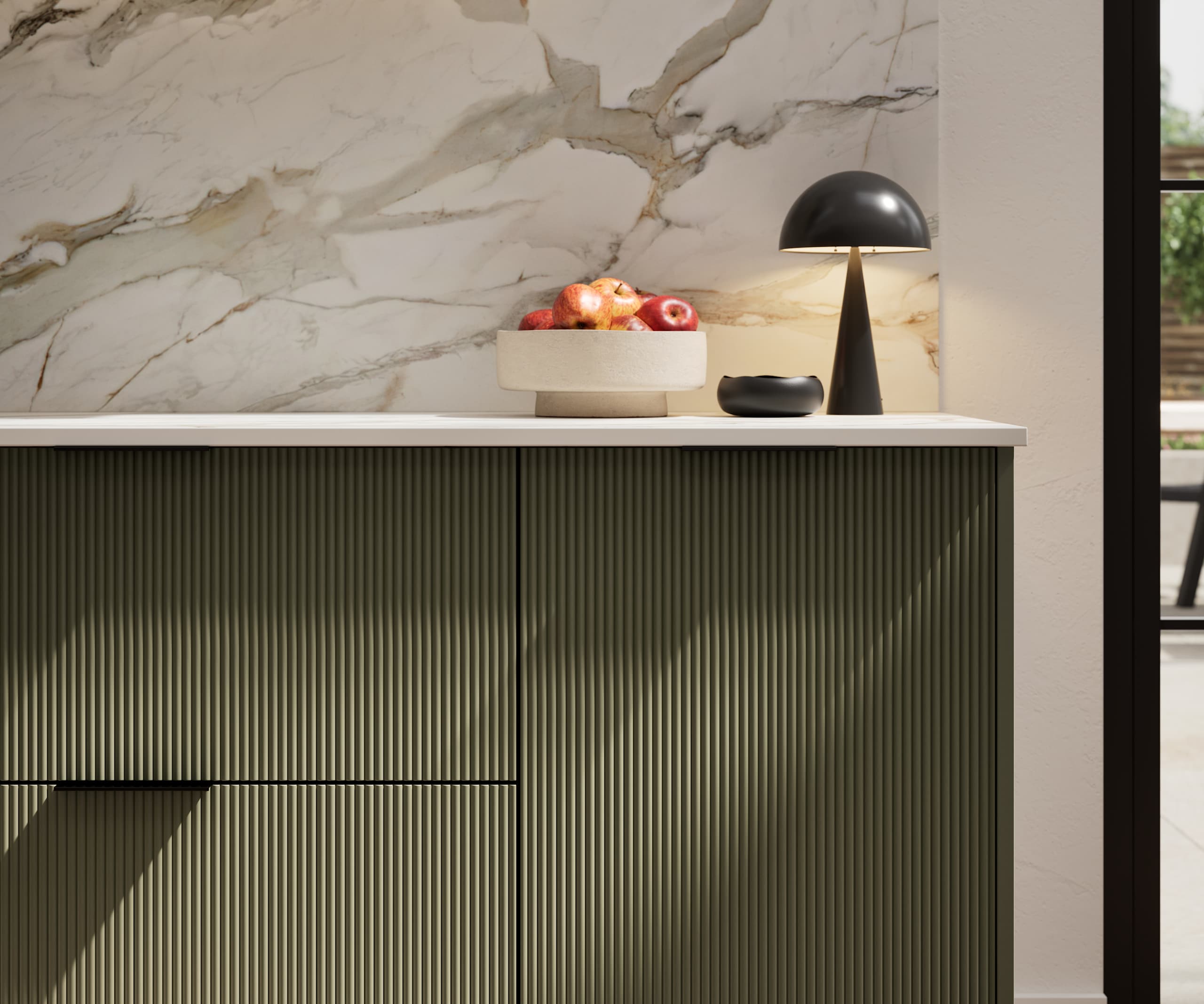 Fluted front kitchen Reed from Magnet in dark green shade Tailored Green, with a marbled splashback and black handles, herringbone wood flooring.