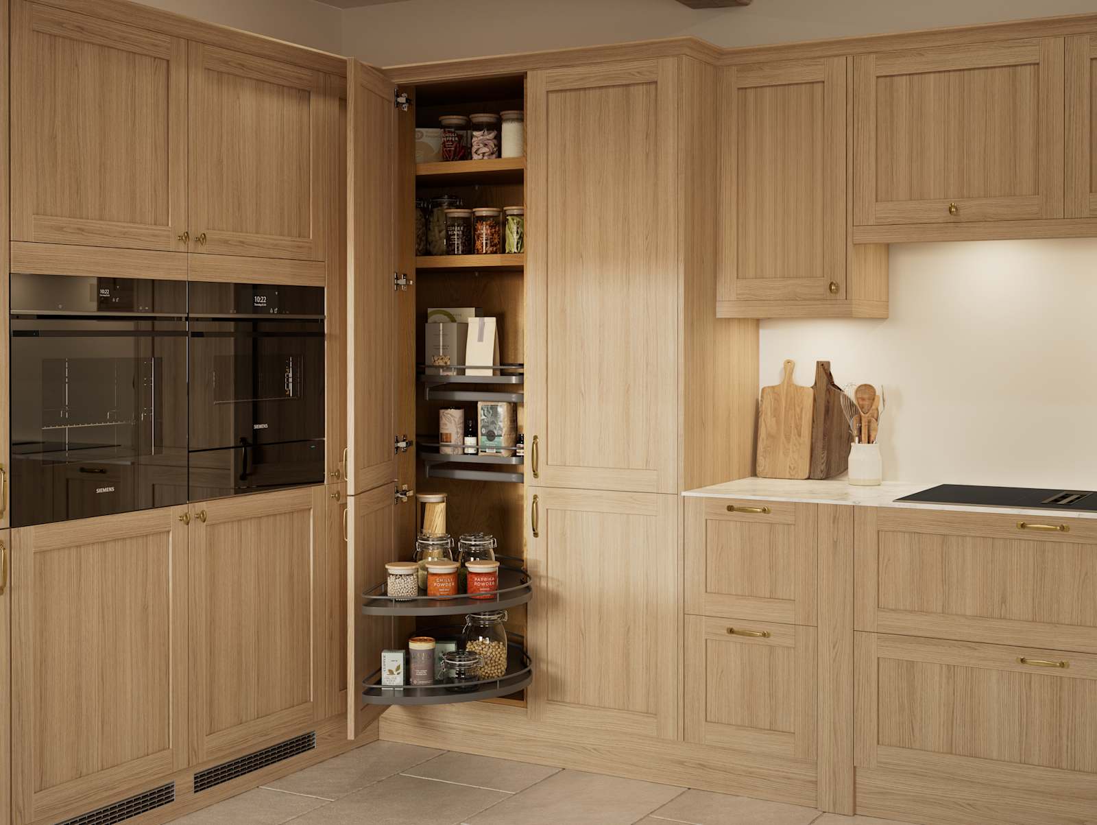 Traditional premium contemporary Shaker kitchen Ambleside in oak with brass knobs and handles, built-in ovens in tall cabinetry, opened tall corner cabinet with oak shelves and pull-out carousel.
