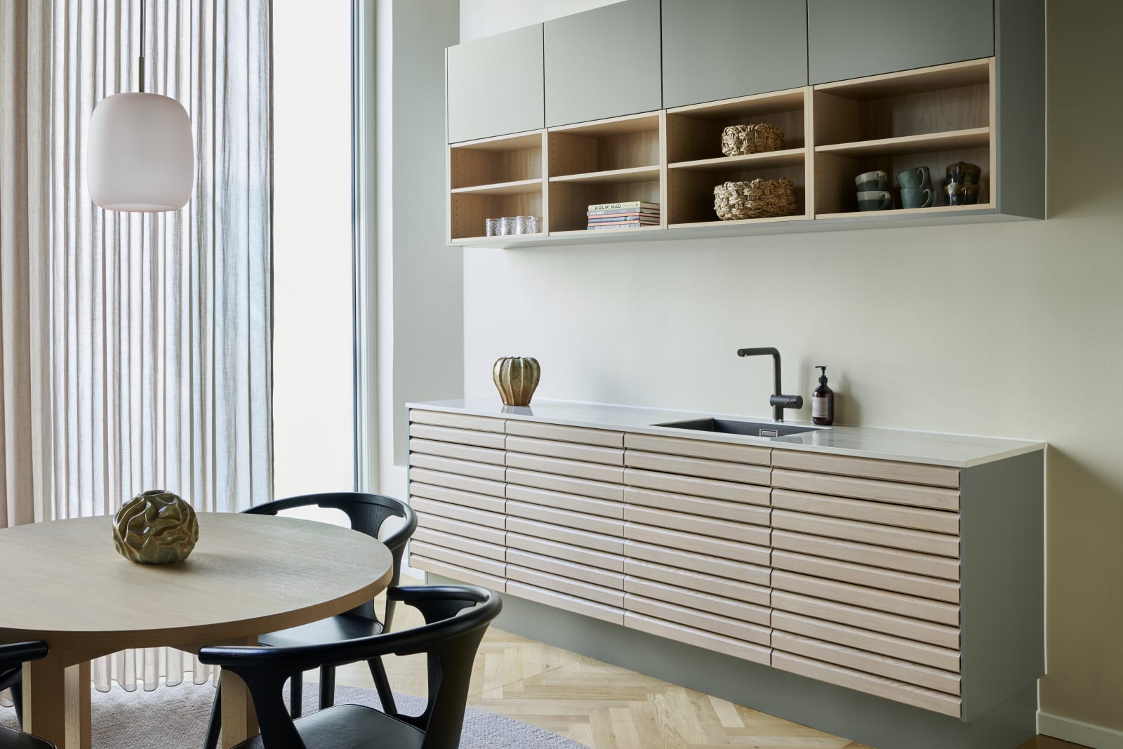 Egetræskøkken Ikon med håndsorterede lameller i massiv eg, kombineret med overskabe og åbne væghylder grebsfrie grønne køkkenet Highline Salvie med indfræsede greb i lågerne fra INVITA