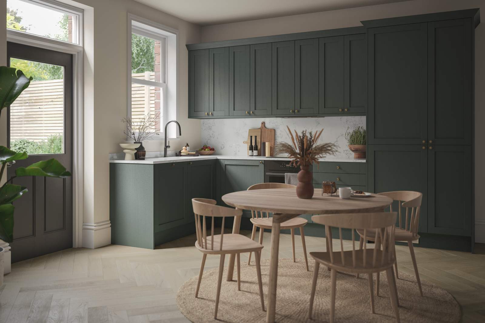 The Ambleside Shaker kitchen in a dark green, seen with a wooden dining table.