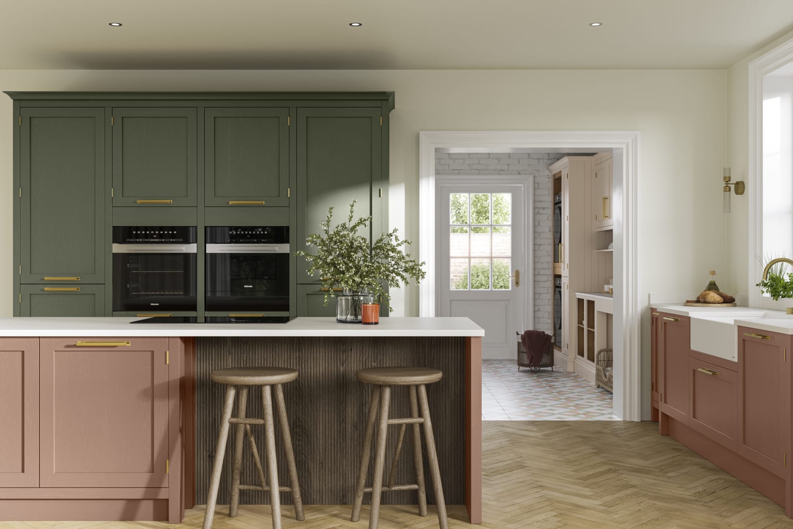 Tall Wardley kitchen cabinets  with built-in ovens, a kitchen island in shade Clay with wooden panelling by seating area and matching wooden bar stools.