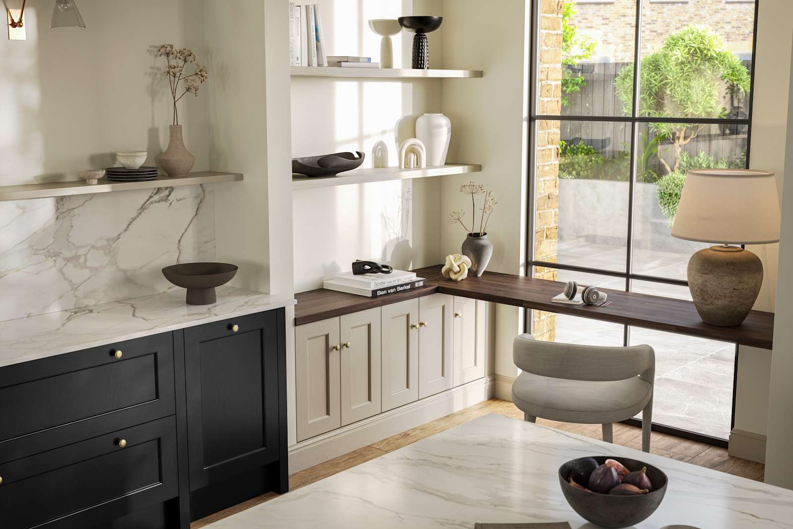 View over kitchen island in Traditional Shaker-style tactile woodgrain Ludlow Sumi Black kitchen, brass details, and dark wood worktop in home office with Ludlow French clay seating area by black metal frame full height window.