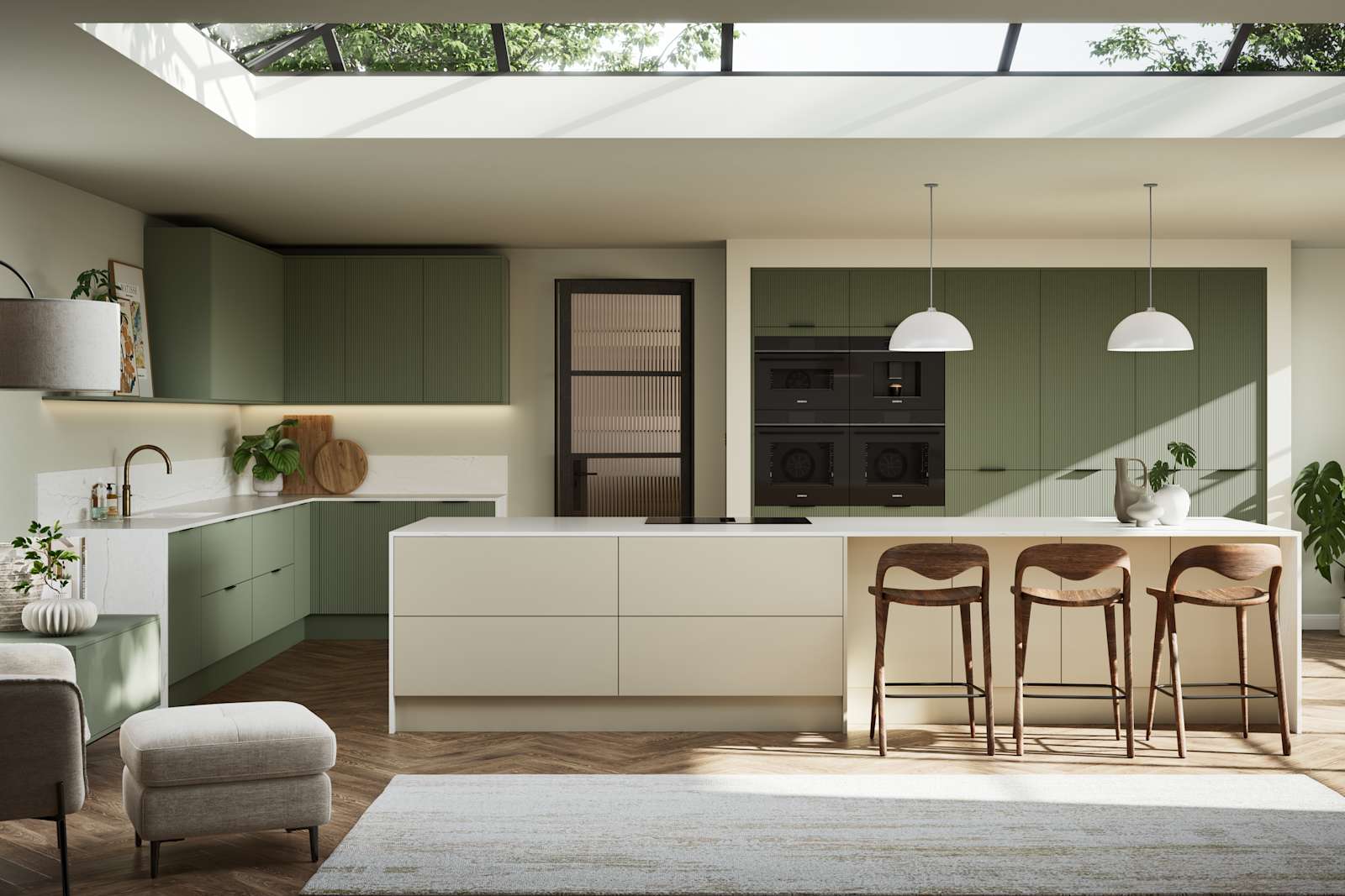 Green fluted kitchen fronts on tall cabinets with built-in appliances and black handles, light neutral shade kitchen island with white worktop and wooden barstools.