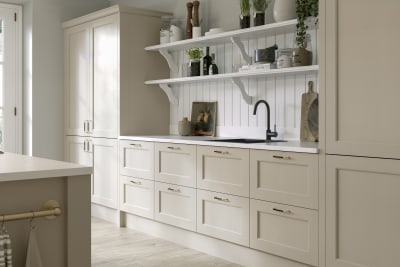 Ludlow kitchen, a Shaker door with a modern country-style in the neutral shade Pebble path paired with white open shelves and wall panelling.