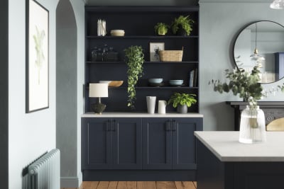 Modern country-style Ludlow Shaker kitchen in dark blue shade Midnight with matching blue open shelves and wall in open floorplan kitchen.