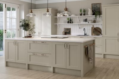 Ludlow Kitchen island and tall cabinets, a Shaker door with a modern country-style in the neutral shade Pebble path with a sleek light worktop and wooden floors.