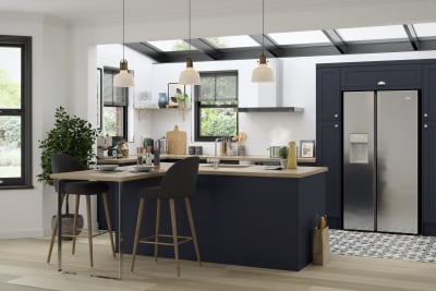 Full room view of Tatton Midnight kitchen from Magnet, a contemporary dark blue narrow frame shaker door, with a kitchen island and bar stools seating.