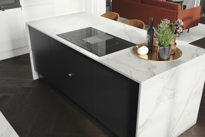 Overhead view of kitchen island, covered with marbled decor side in Magnet's minimal maximalism Hoxton kitchen in Sumi Black.