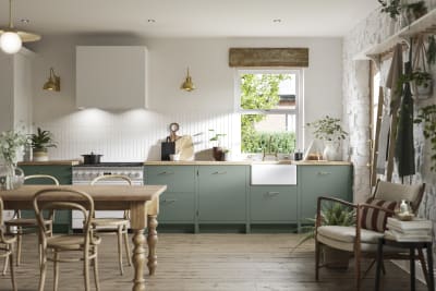 Soho Eucalyptus green open plan kitchen in contemporary cottage with a light wood dining table.