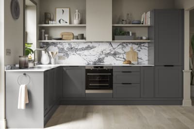 A dark grey Shaker kitchen with Charcoals cabinetry, paired with marble splashback and stylish black handles.