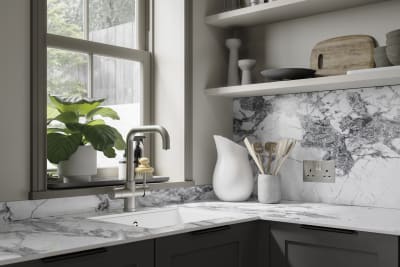 Close-up of marble worktop and backsplash in dark grey shaker kitchen.