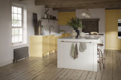 Alt text: Open floorplan shaker kitchen in the bright and beautiful yellow shade Harvest, paired with a kitchen island with matching frame door cabinets in the shade Limestone.