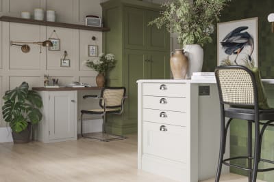 Off-white and olive green kitchen featuring shaker-style cabinetry and a desk area within the space.