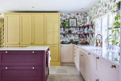 Wide image of sink, kitchen island and pantry larder. Ludlow cabinetry from Magnet in colours Burlington Red, Chalk blush and Harvest in Heritage classic with a contemporary twist.