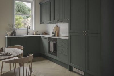 A contemporary Shaker kitchen in Ambleside with dark green cabinets and a wooden table.