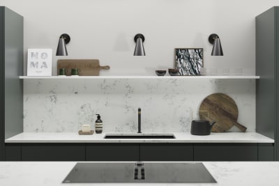 A Duxbury kitchen sink set up featuring marble-effect worktops and backsplash, black sink and tap and open shelving with wall lights and accessories.