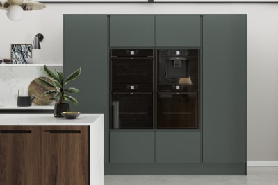 Black appliances integrated into full-height door units from Magnet's Duxbury range, seen in a rich dark green.