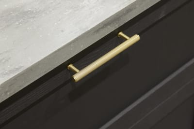 A close-up view of Ambleside drawer frontals in Graphite, with brass bar handles and grey worktop.