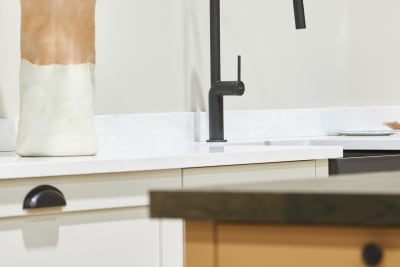 Close-up of black tap in white shaker kitchen Wardley with a corner of kitchen island in the foreground.