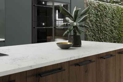 A kitchen island created using Portobello cabinets in Umbra, paired with a light worktop and decorated with botanical accents.