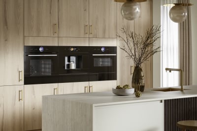 Modern Portobello kitchen cabinets in Bosco are finished with brass bar handles.