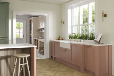 Wardley kitchen cabinetry in shades Clay and Thyme, as well as lighter beige shade Utility room visible through wide archway.