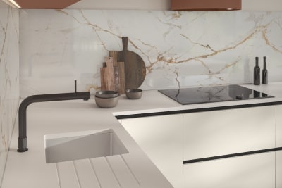 White Integra Soho handleless slab front cabinetry, white marbled splashback paired with a white dekton worktop and black tap.