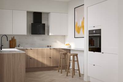 Ascoli Natural Oak kitchen cabinetry covered by a white worktop extending from cabinets to a bar seating area with light wood stools, Gloss white wall cabinets and, tall cabinets with a built-in oven all paired with black accessories, wood floors.