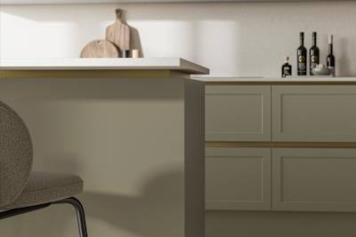 Integra Dunham French Clay, a handleless shaker frontal with brass details and a white worktop..