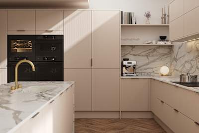Fluted front kitchen Reed from Magnet in light warm neutral shade Shell, with a marbled splashback and worktop, brass tap in kitchen island sink
