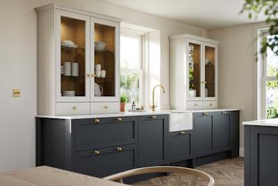 Contemporary Shaker kitchen Ambleside from Magnet in deep blue shade Lake with beige glass fronted dresser cabinets, belfast ceramic sink and brass knobs matching brass tap