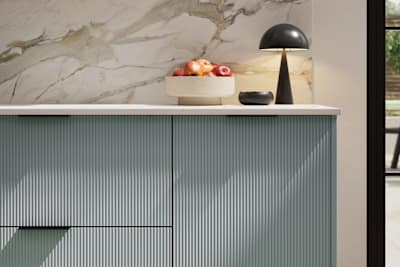Fluted front kitchen Reed from Magnet in light blue shade Duck Egg, with a marbled splashback and black handles, herringbone wood flooring.