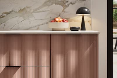 Fluted front kitchen Reed from Magnet in rich neutral green shade Baked Clay, with a marbled splashback and black handles, herringbone wood flooring.