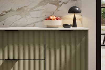 Fluted front kitchen Reed from Magnet in deep green shade Balmoral, with a marbled splashback and black handles, herringbone wood flooring.