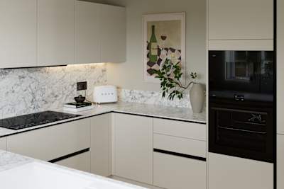 Light neutral shade fluted kitchen  with integrated appliances, white and grey marble worktop and upstand.