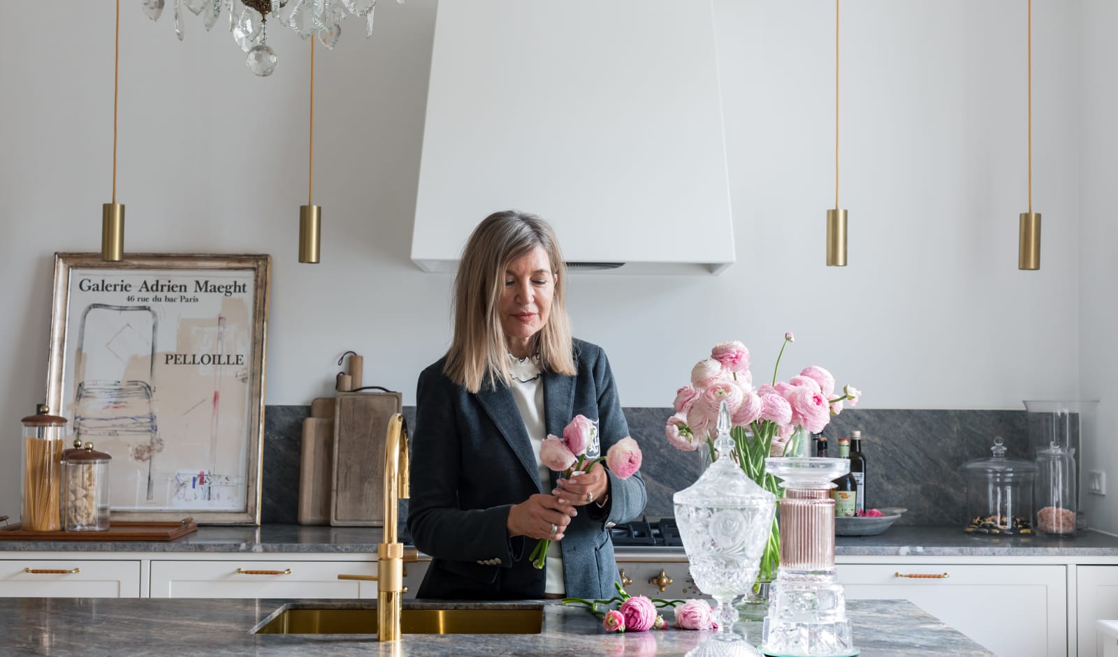 Lichtgrijze keuken met natuurstenen werkblad en messing details