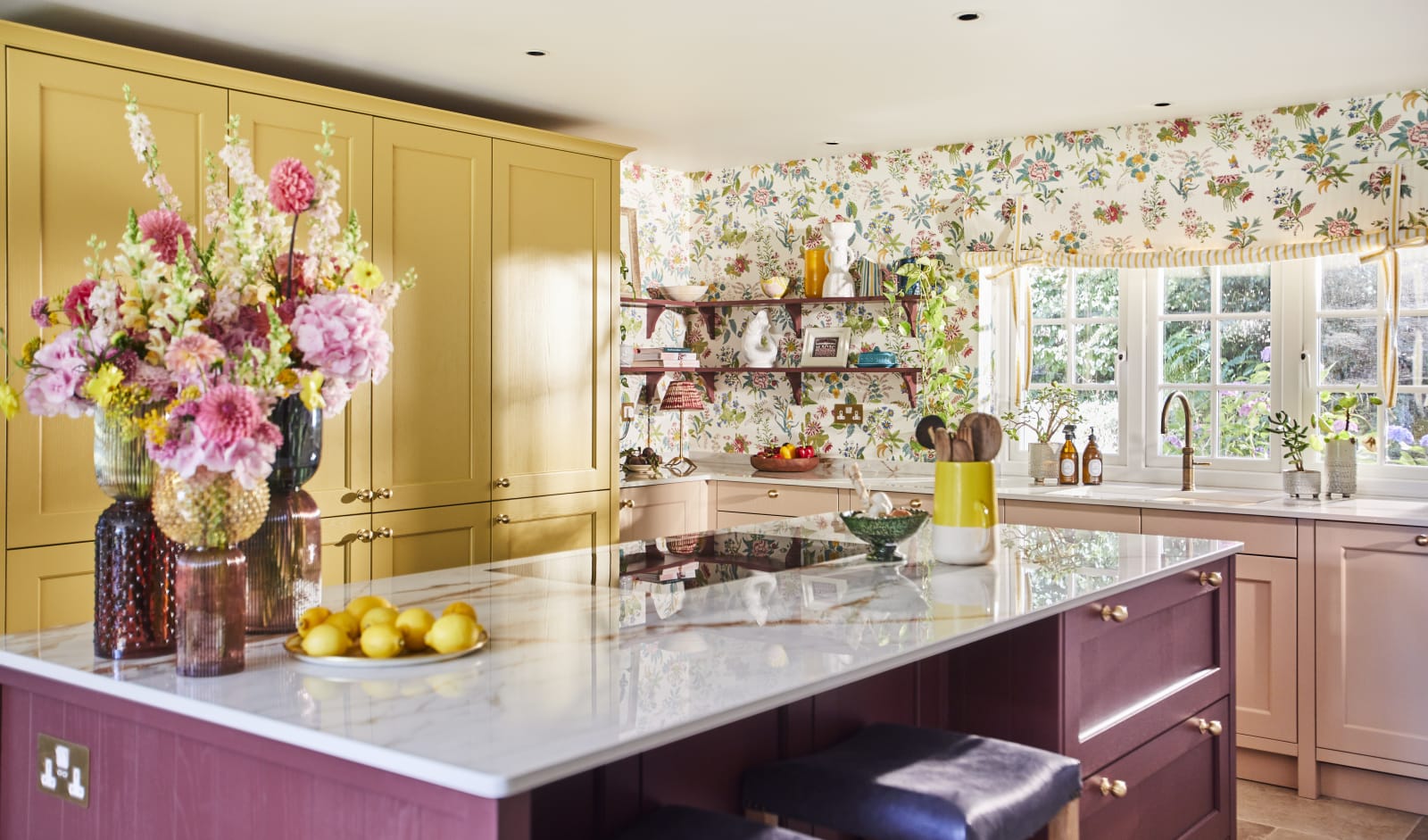 View of Burlington Red kitchen island in Sophie Robinson's vibrant Ludlow kitchen from Magnet with cabinetry in colours Harvest and Chalk Blush.