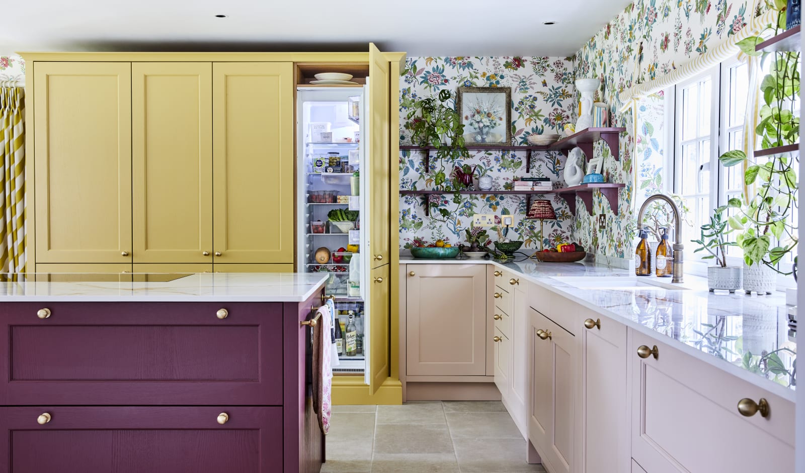 Wide image of sink, kitchen island and opened integrated Fridge. Ludlow cabinetry from Magnet in colours Burlington Red, Chalk blush and Harvest in Heritage classic with a contemporary twist.