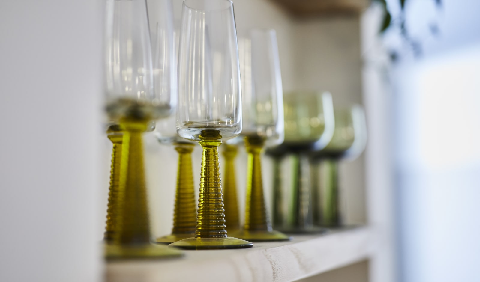 Close-up of wine glasses on an open shelf