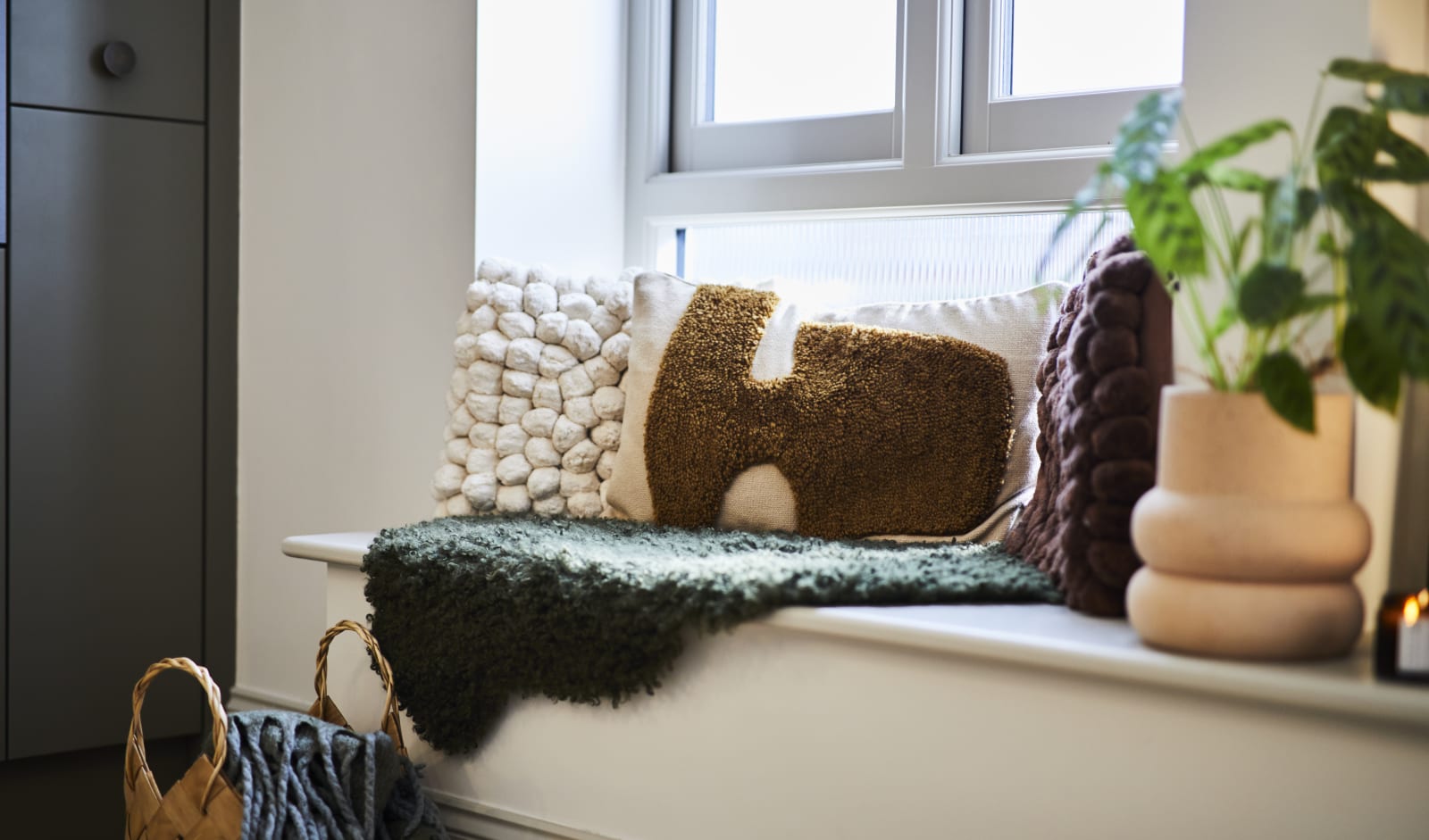 Close-up of seating area on low seating bench with pillows i earth tones