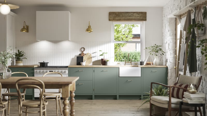 Soho Eucalyptus green open plan kitchen in contemporary cottage with a light wood dining table.