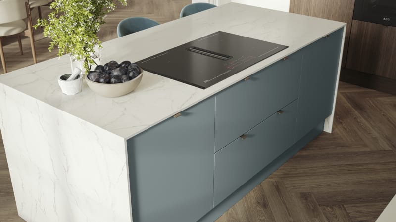 Overhead view of kitchen island with marbled dekton worktop, integrated hob and Soho Duck Blue cabinetry from Magnet.