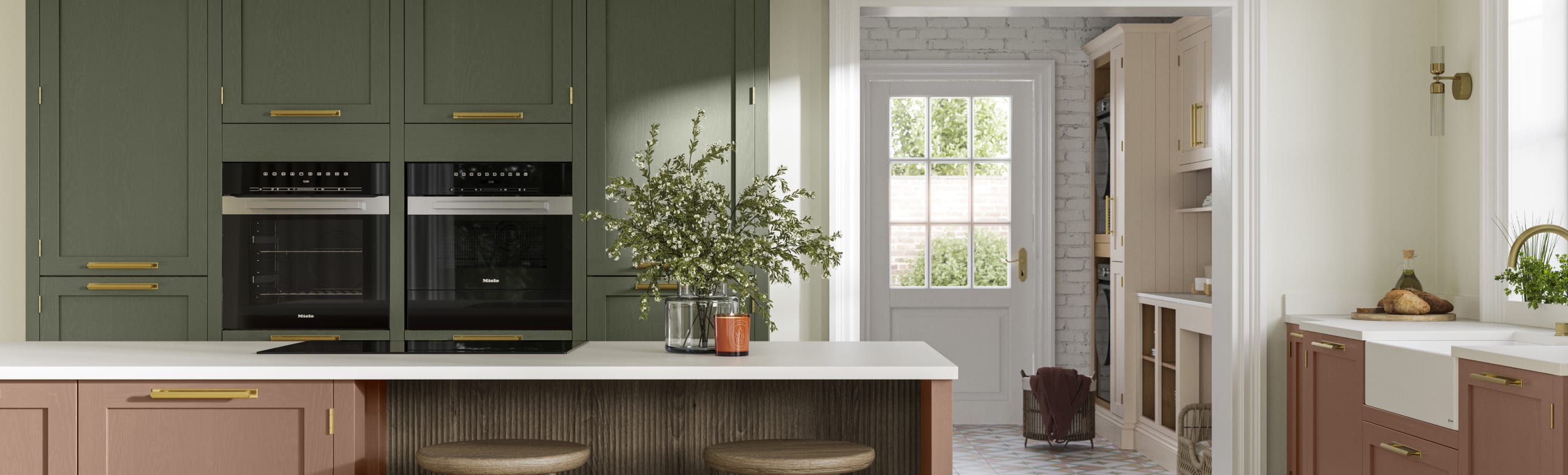 Tall Wardley kitchen cabinets  with built-in ovens, a kitchen island in shade Clay with wooden panelling by seating area and matching wooden bar stools.