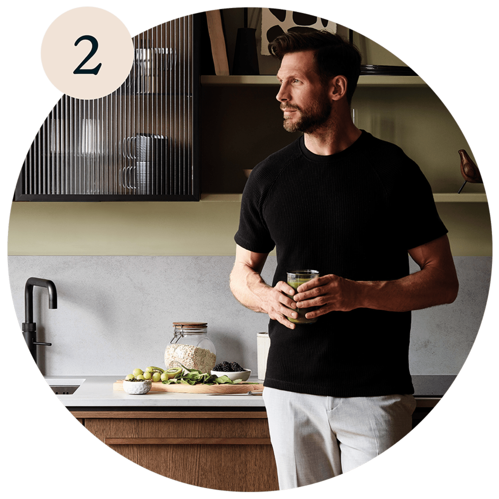 A man in a modern kitchen with wood fronts