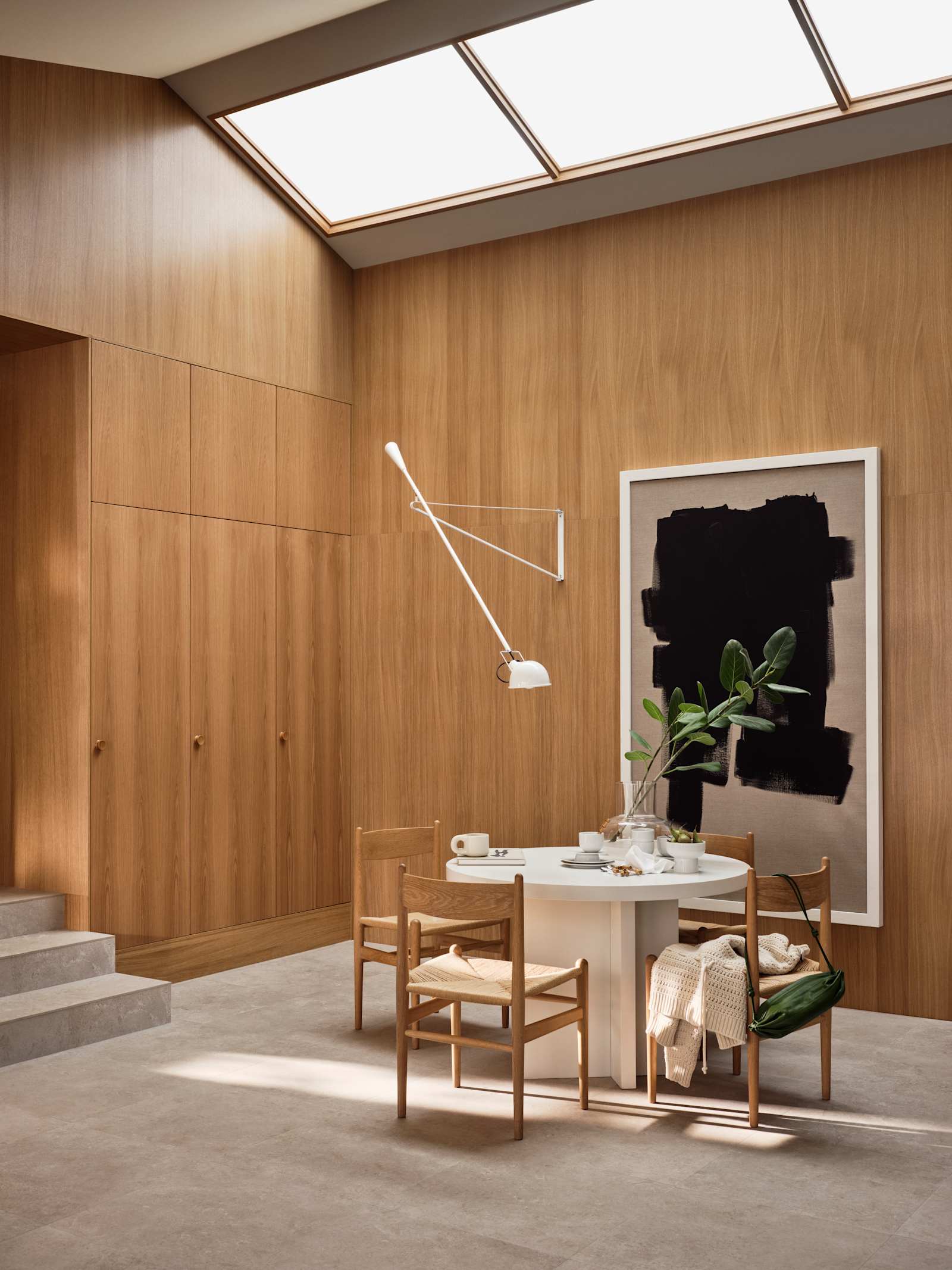 Jubilæumskøkken fra INVITA med elegant træfinér eg, matchende vægpanel og skaber inspireret av 1970'erne, hvid bord med stoler i tre