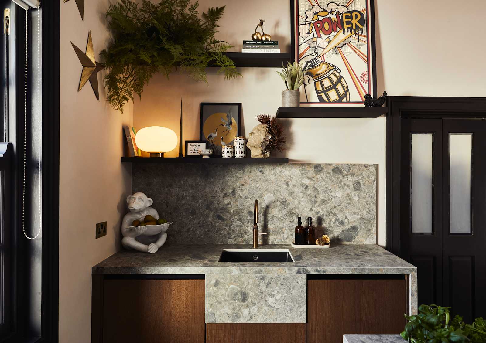 Sink area with Dekton in Ceppo backsplash and worktop, Nordic Nature cabinetry and a brass Quooker tap, combined with plants on open shelves on wall