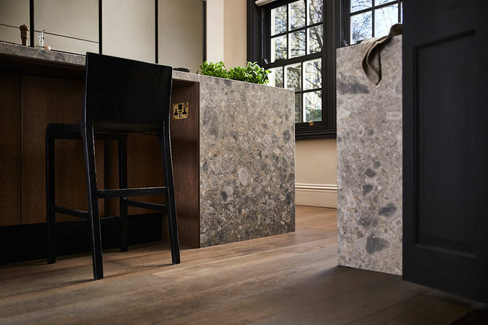 Floor level view of kitchen island seating area with a black tall chair
