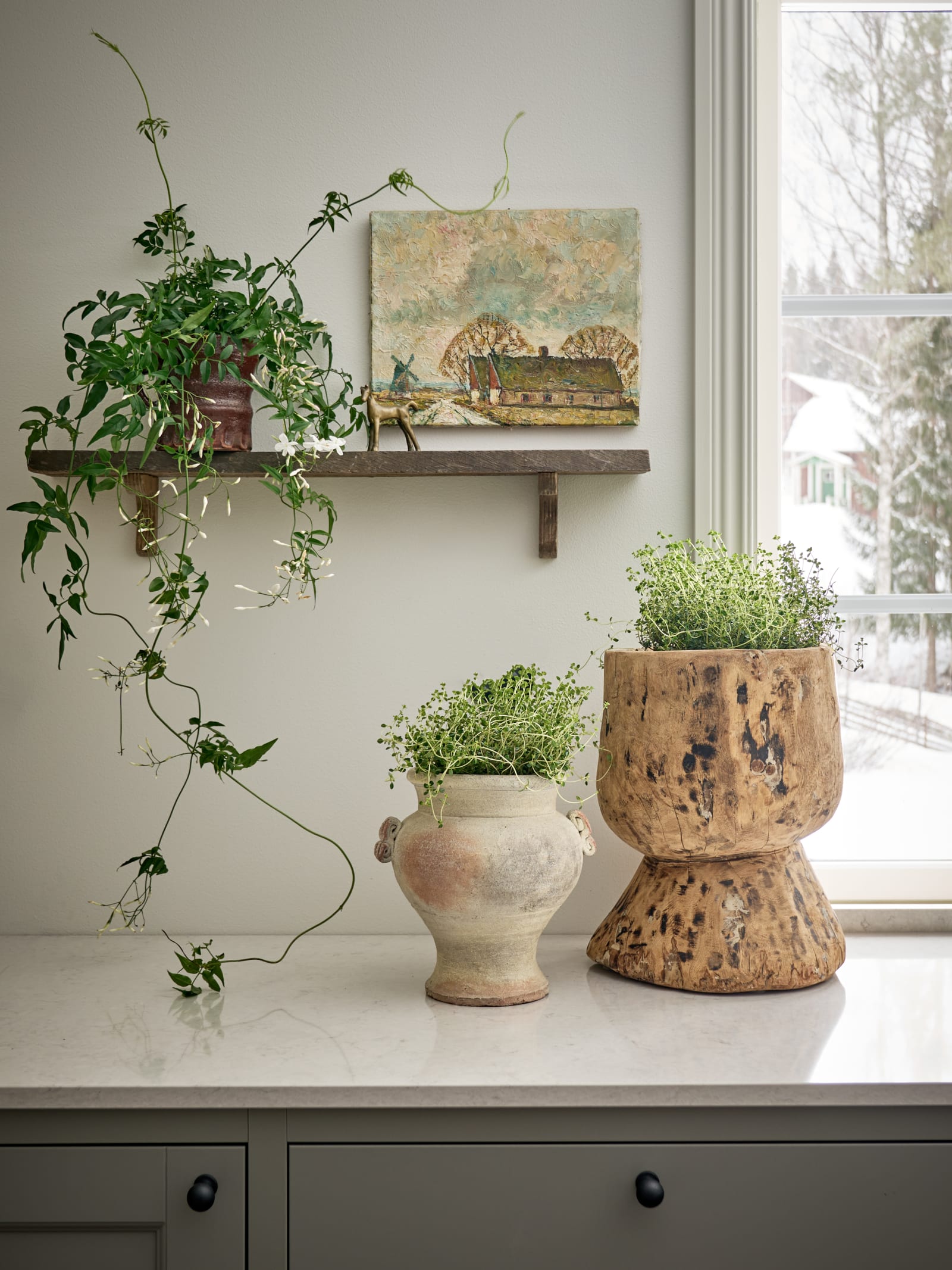 En kökshylla i Malin Berghagens kök med grönska.